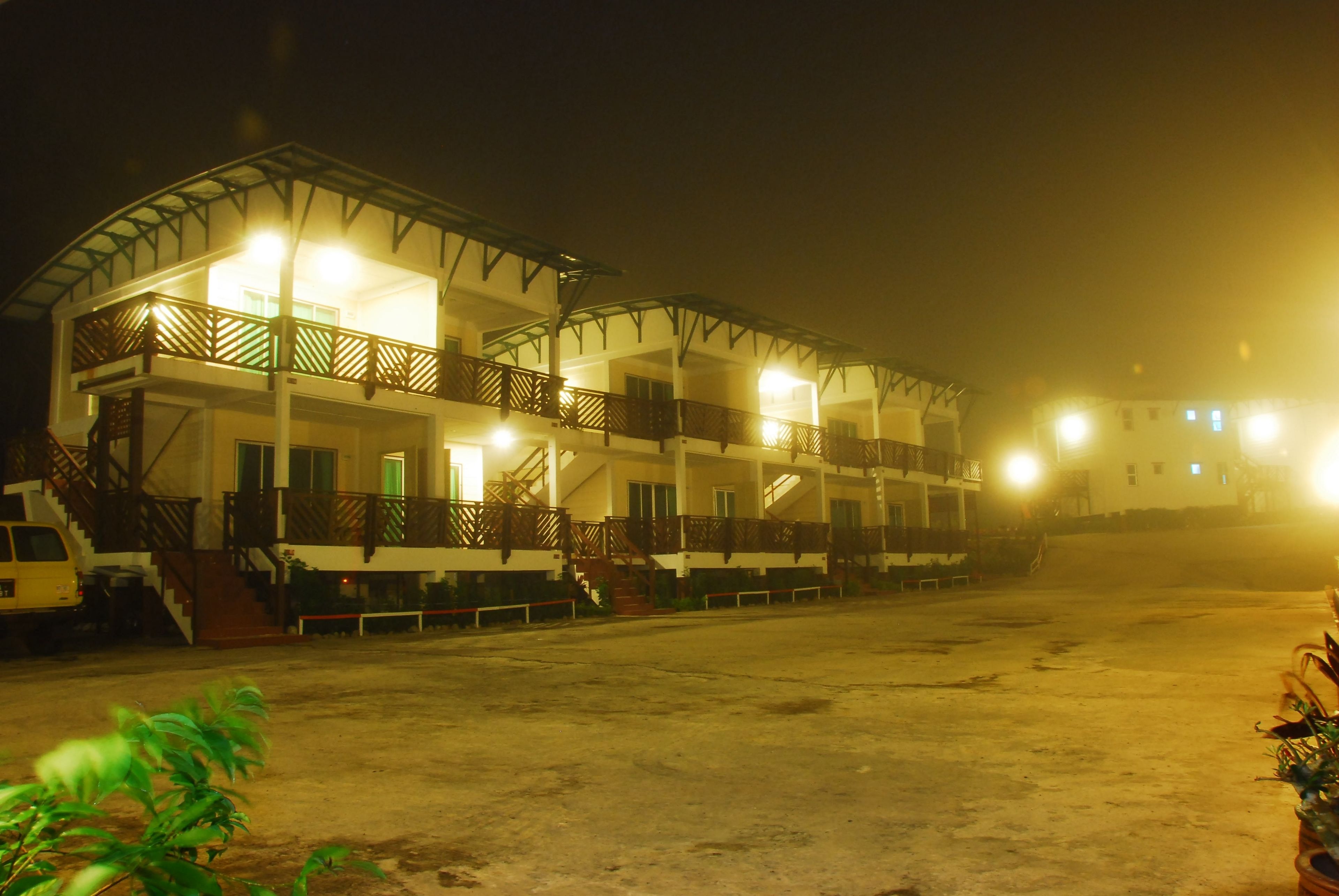A multi-story hotel with balconies and a covered outdoor area.