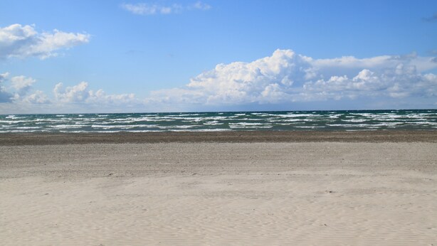 A beach with a clear sky and ocean waves. - Plovers Cove Cottage (Wasaga Beach)