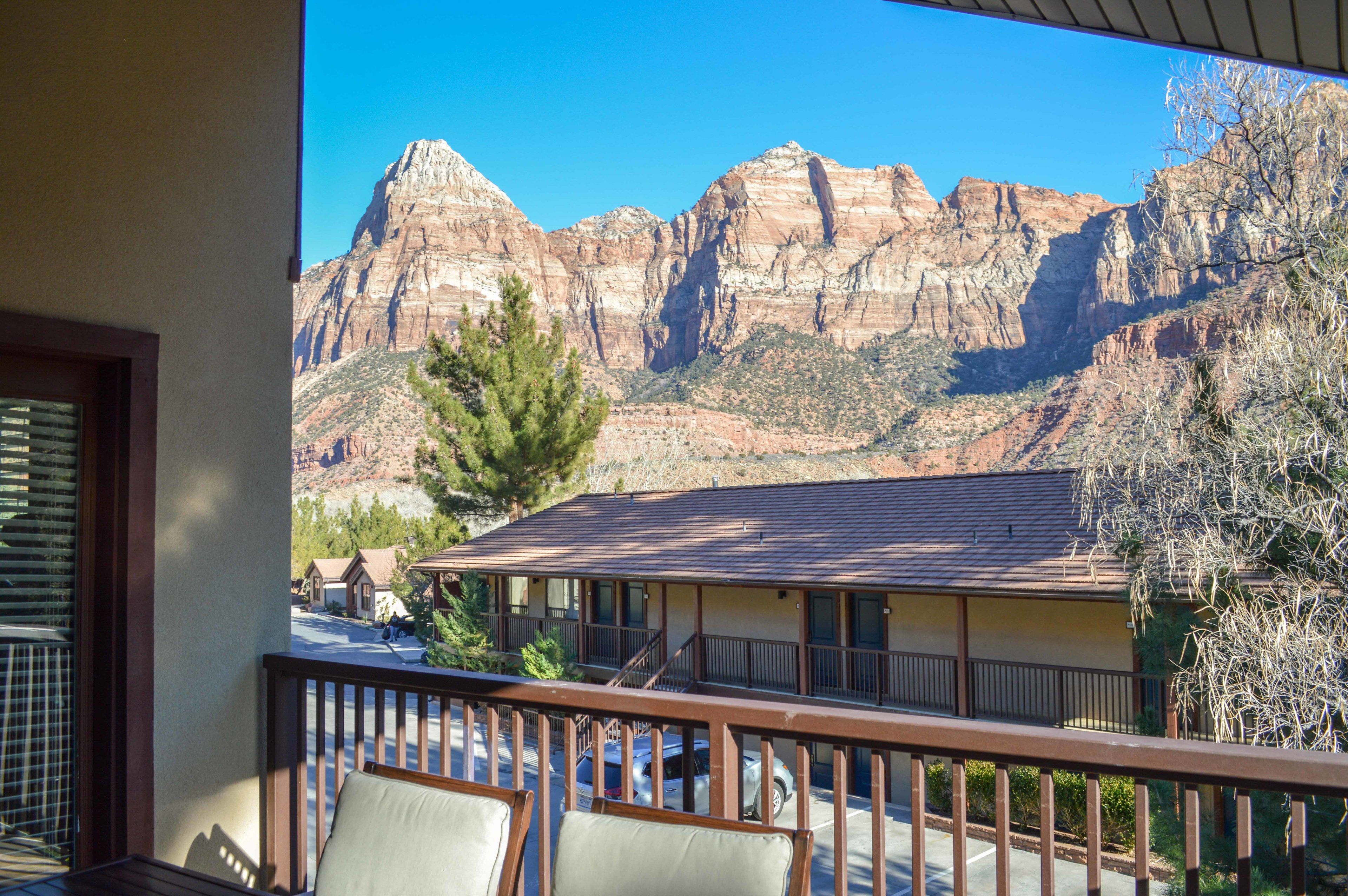 A hotel with a balcony overlooking a mountainous landscape.