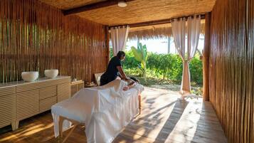 Relax in a serene spa room with a massage table and a wooden bench.