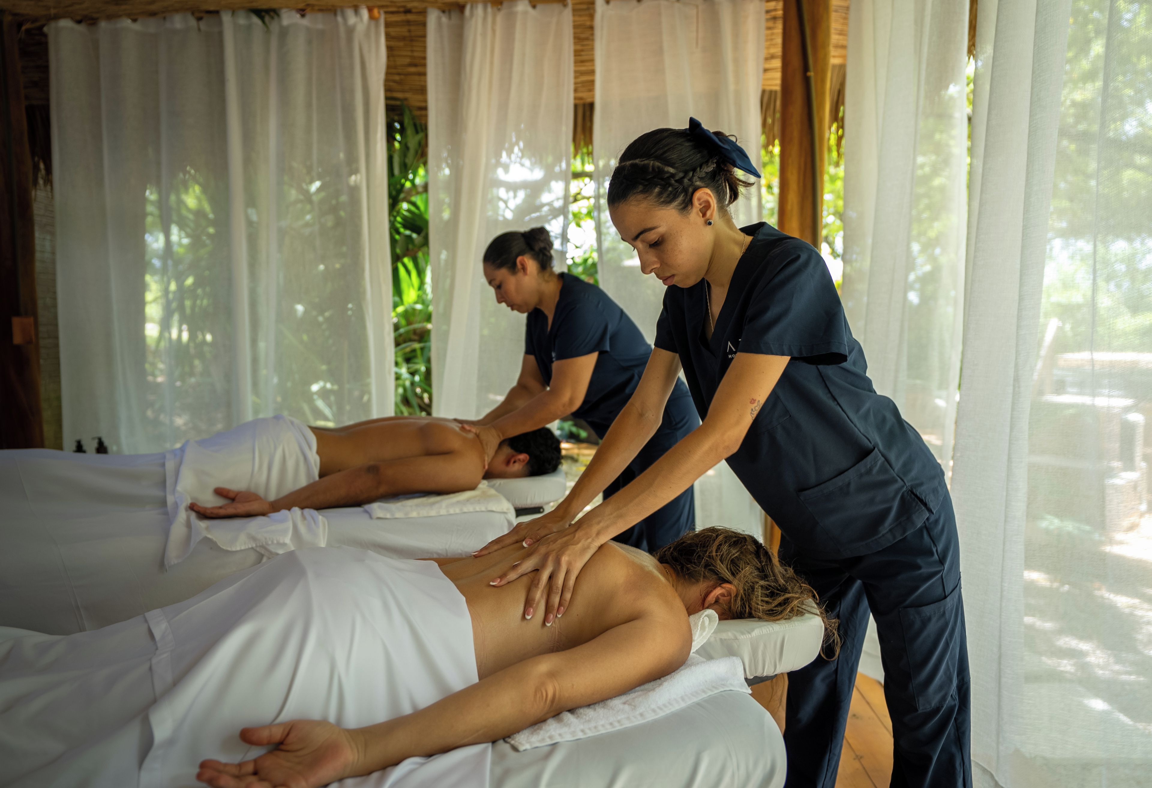 A massage therapy room with two clients receiving treatment.