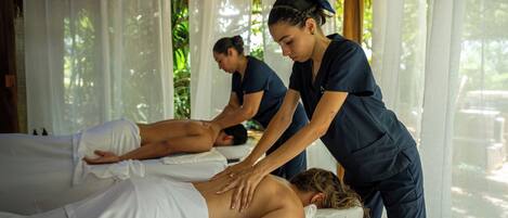 A massage therapy room with two clients receiving treatment.