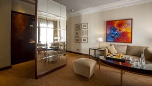 A hotel room with a large mirror, a sofa, a coffee table, and a painting on the wall. - Atlantic Agdal (Rabat)
