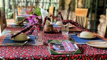 A dining table set with plates, glasses, and a menu.