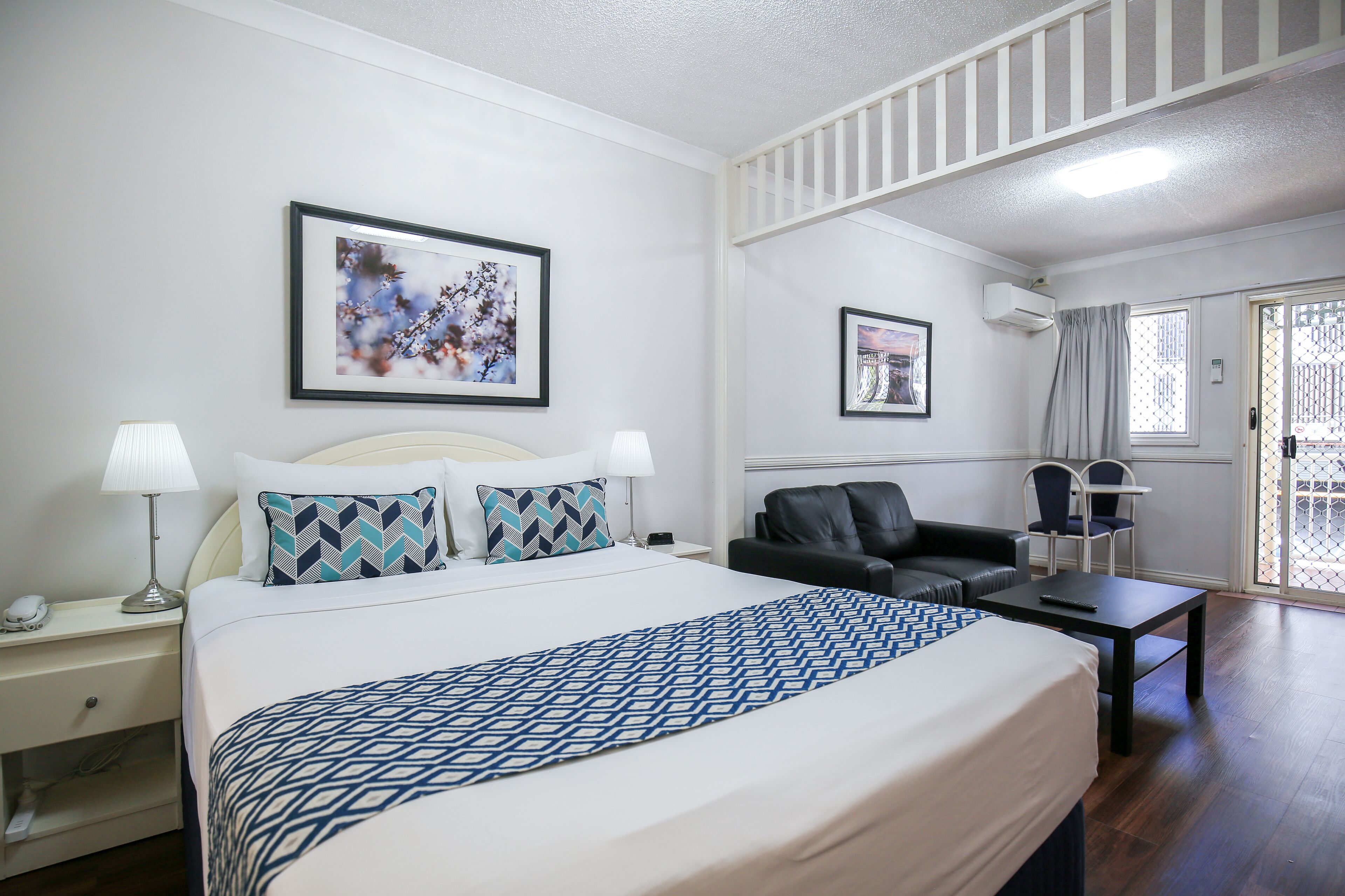 Une chambre d’hôtel avec un lit, un bureau, une chaise et un canapé.