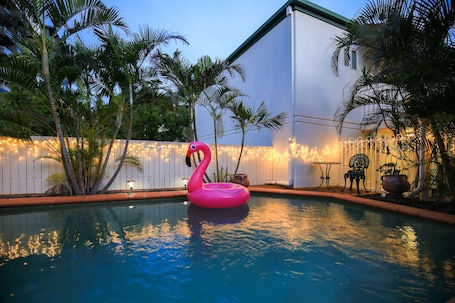 Una piscina al aire libre, sillones reclinables de piscina