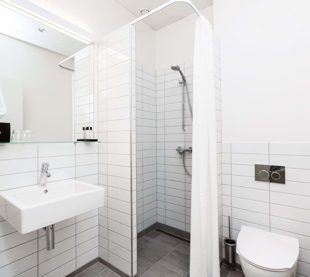 Une salle de bain moderne avec une douche à parois de verre, un lavabo blanc et des toilettes.