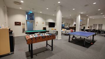 Ett rum med ett fotbollsspel, ett bordtennisbord och ett biljardbord.