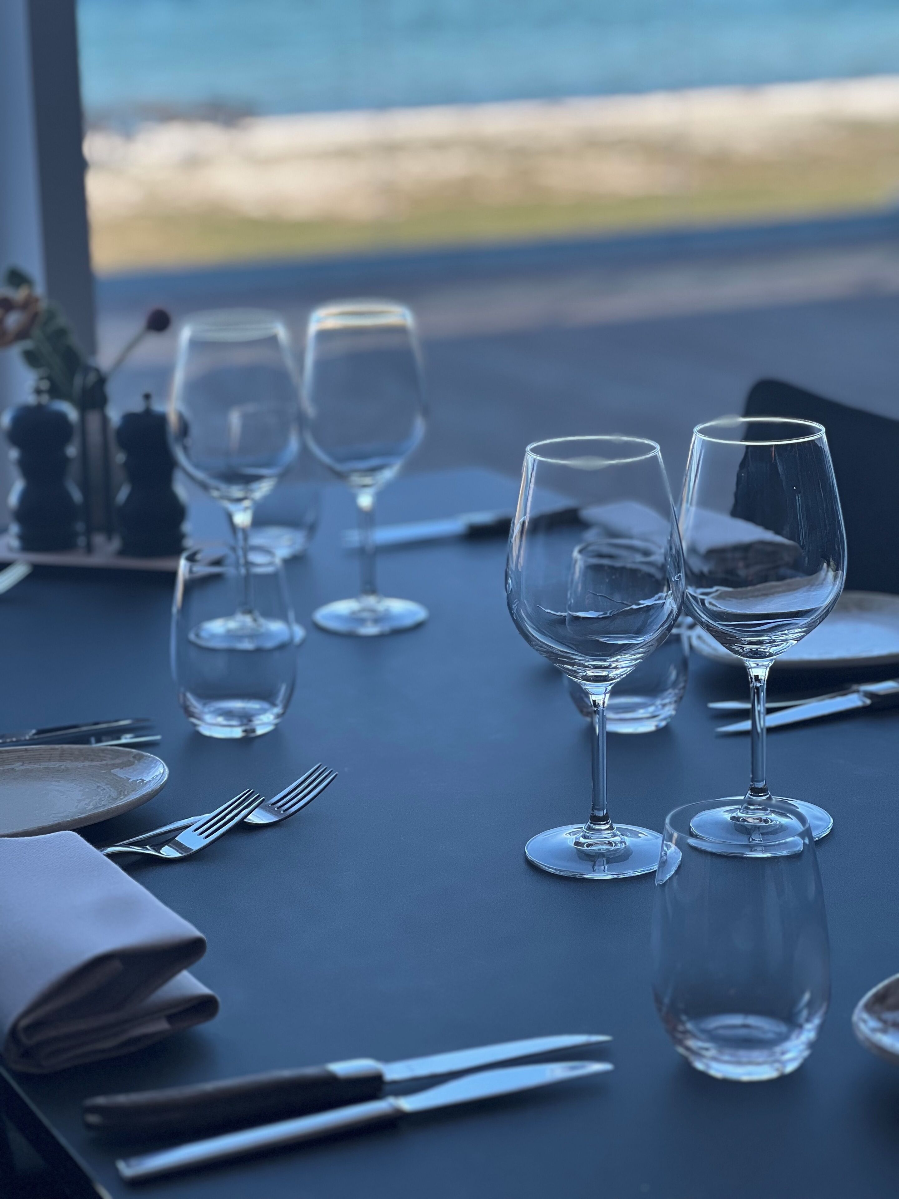 A table set for dining with wine glasses, cutlery, and plates.
