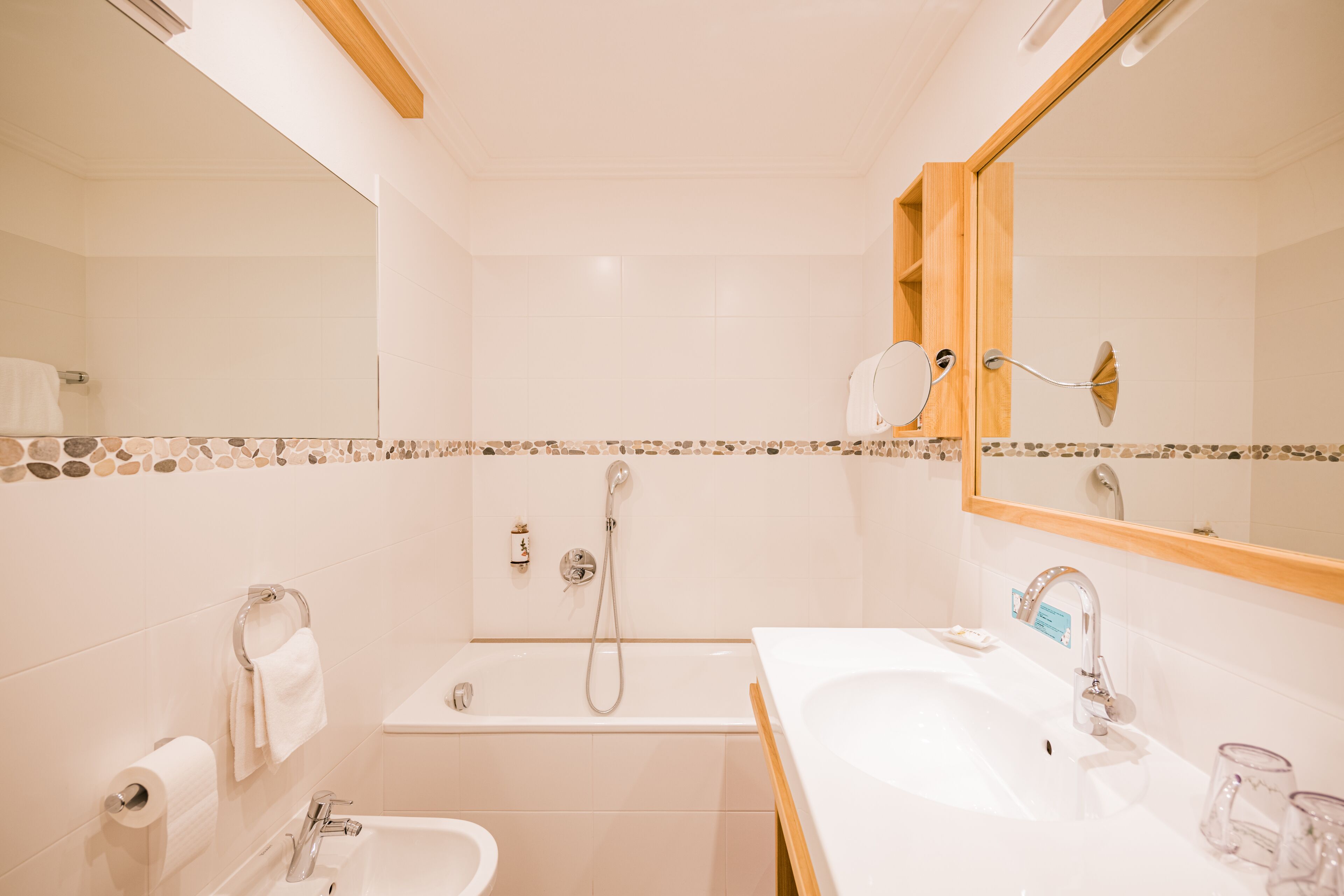 Un baño con bañera, lavabo y espejo.
