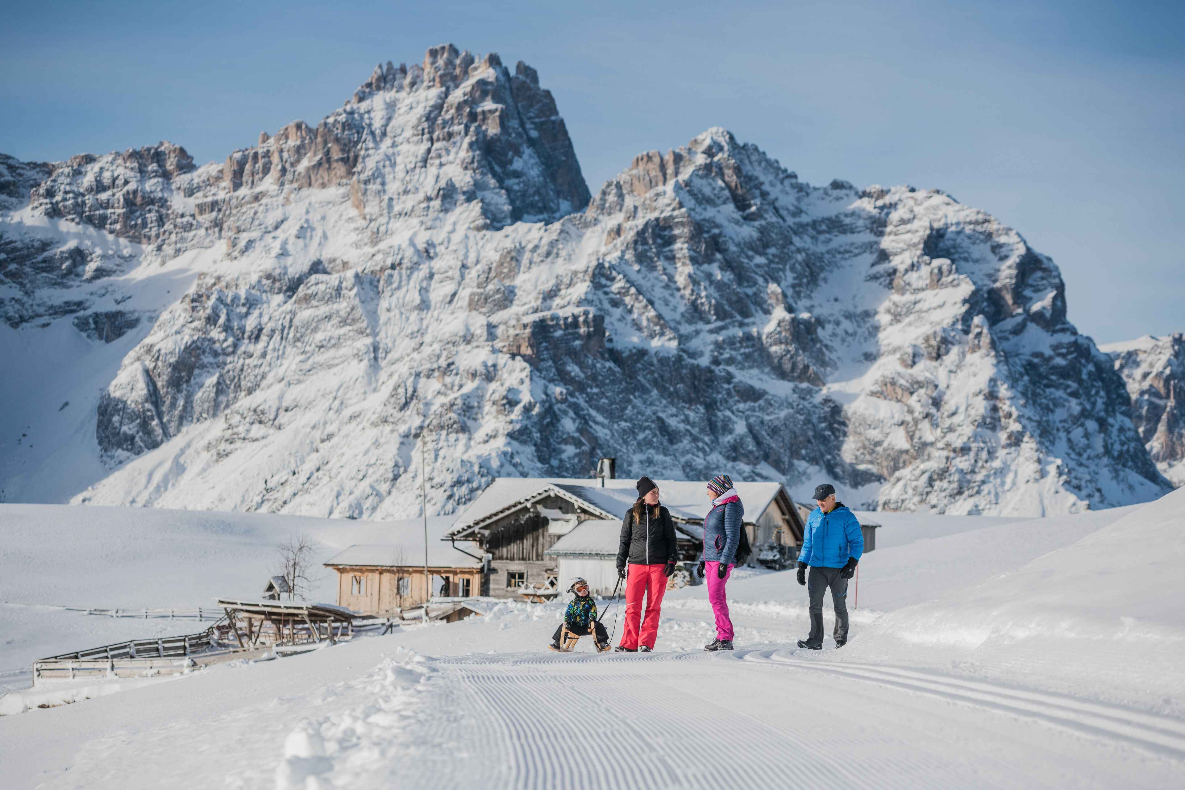 A snowy mountain landscape with a wooden cabin and a ski slope.