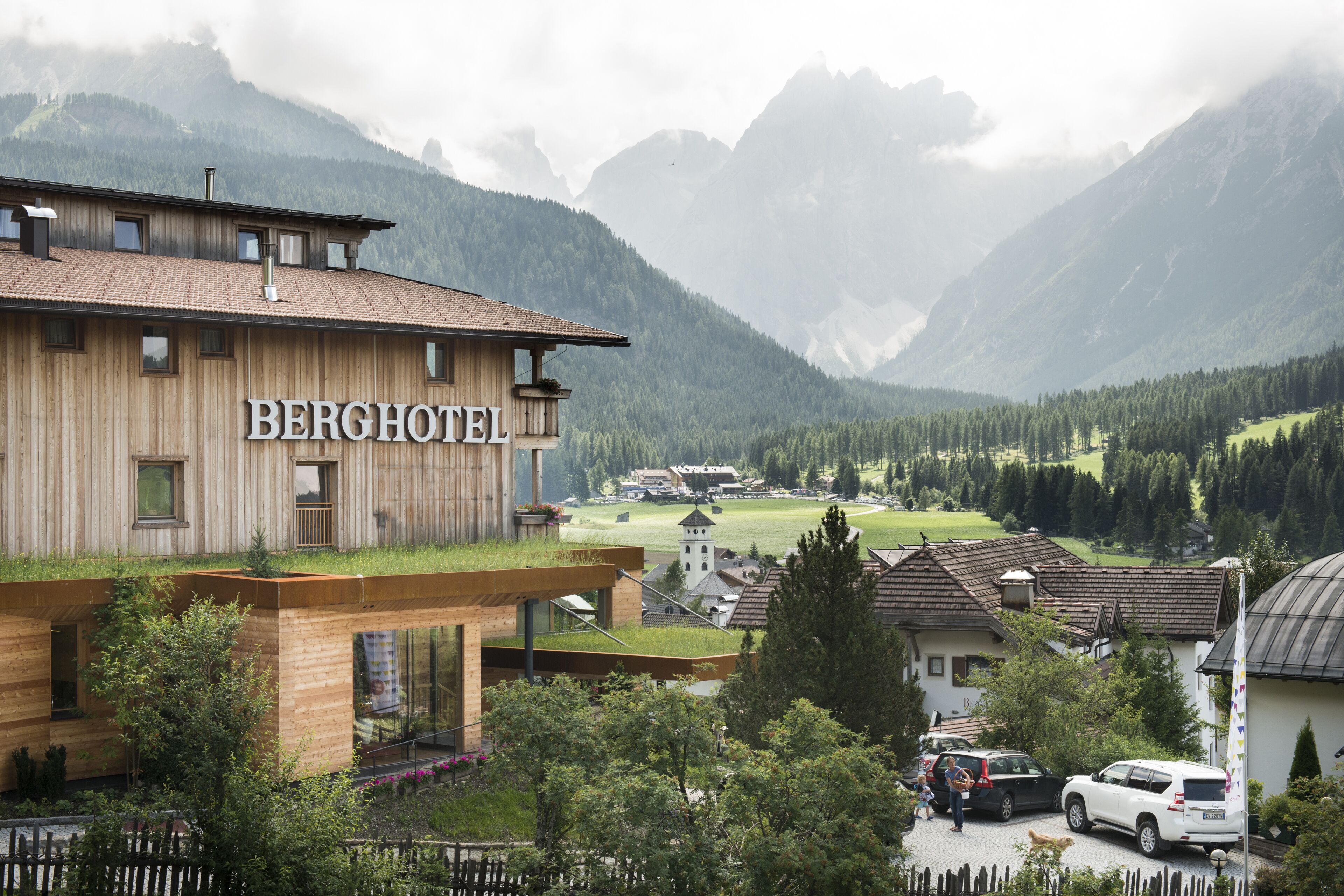 A hotel with a wooden facade and a sign that reads "BERGHOTEL".