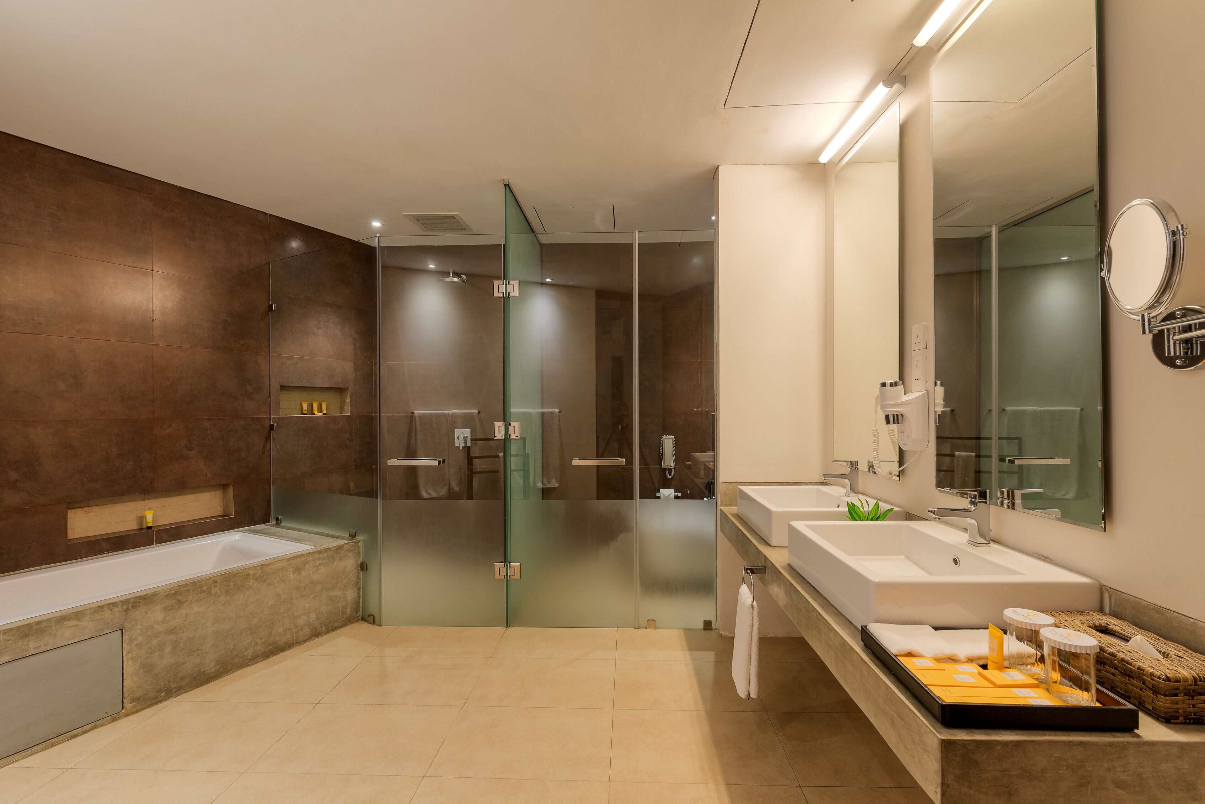 A modern bathroom with a glass shower enclosure, two sinks, and a large mirror.