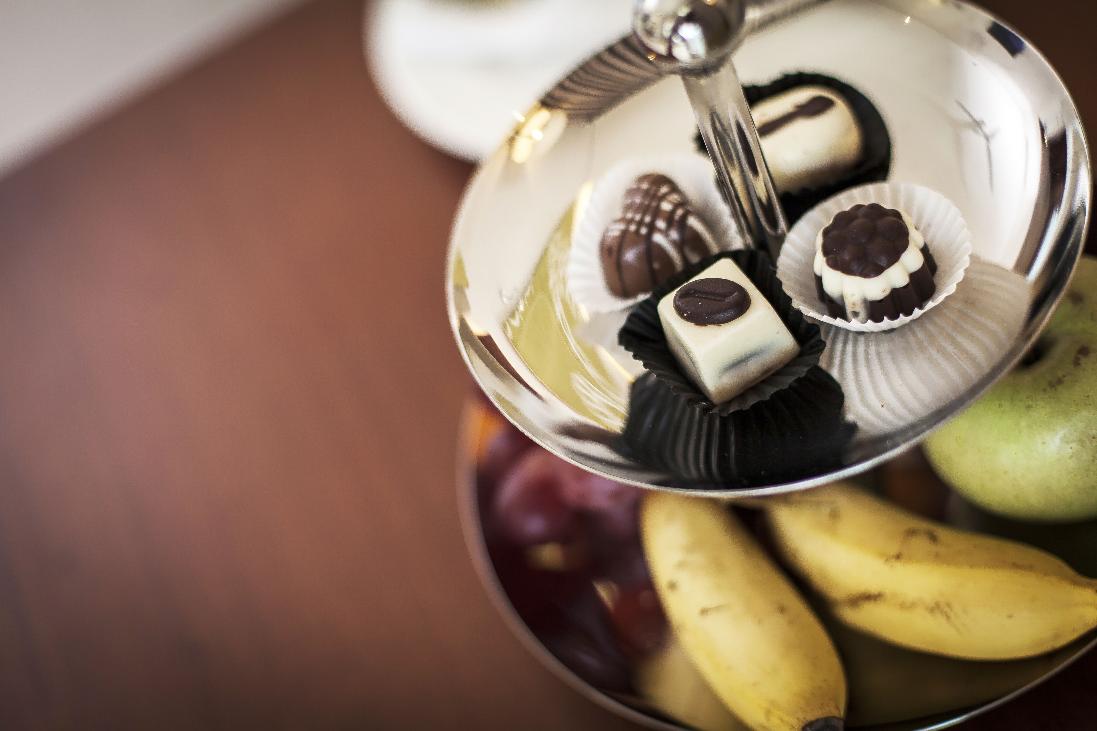 A bowl of assorted chocolates and bananas.