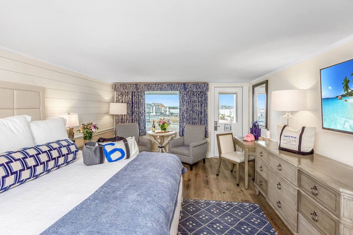 Habitación de hotel con cama, escritorio, silla, cómoda y vistas a la ciudad.