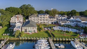 A marina with multiple boats docked, surrounded by residential buildings with balconies and a well-maintained lawn. - The Harborside Inn (Edgartown)
