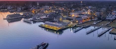 Une ville située au bord de l’eau, avec un quai, des bâtiments et un bateau.