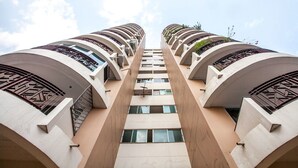Un edificio de gran altura con fachada simétrica, varios balcones y un corredor vertical central.
