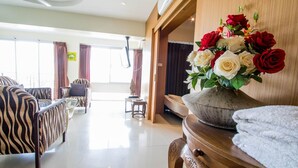 Una sala de estar moderna con un sofá, una mesa de centro de madera y un jarrón de flores.