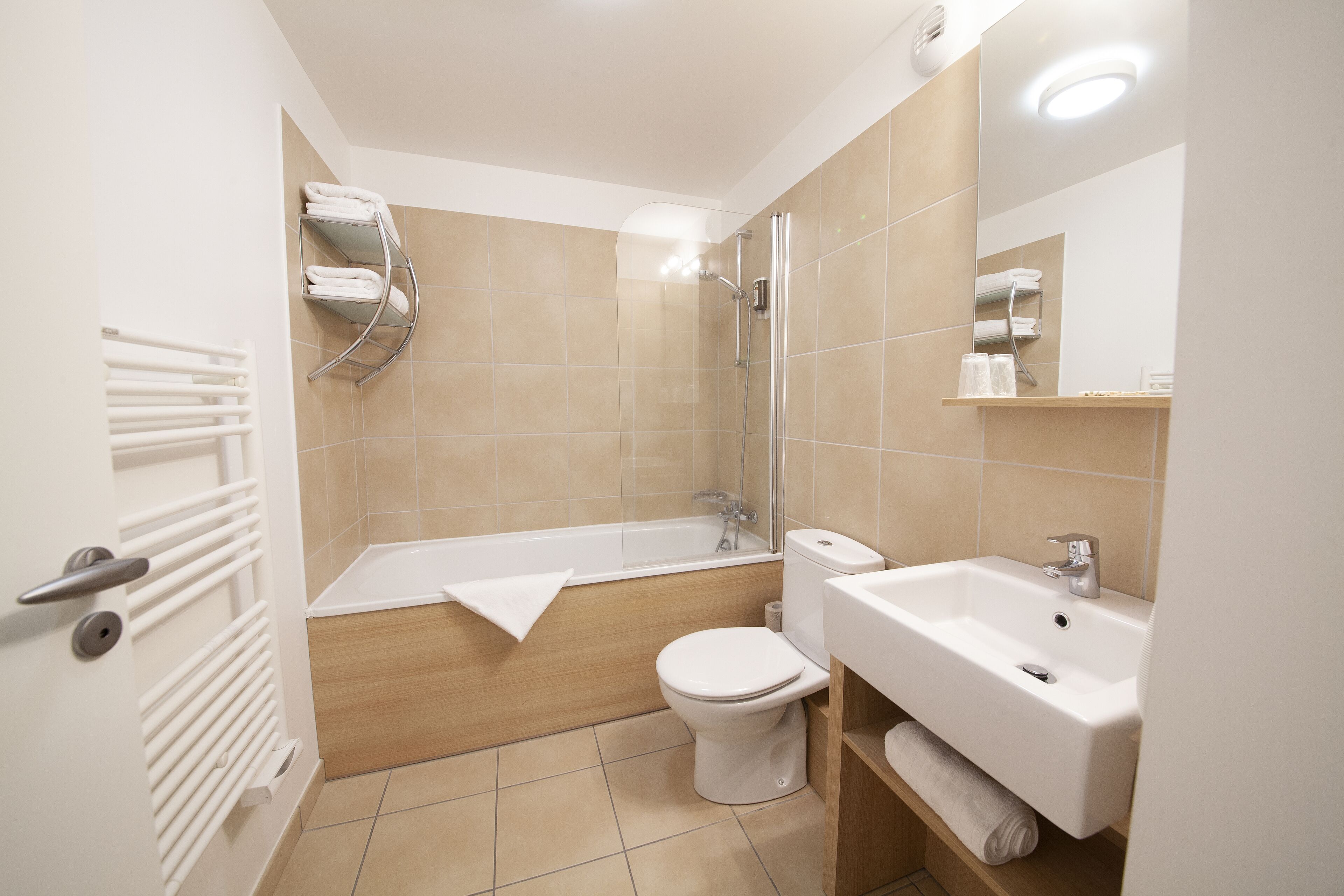 A modern bathroom with a bathtub, toilet, and sink.