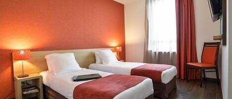 A hotel room with two beds, a TV mounted on the wall, a chair, and a window with curtains.