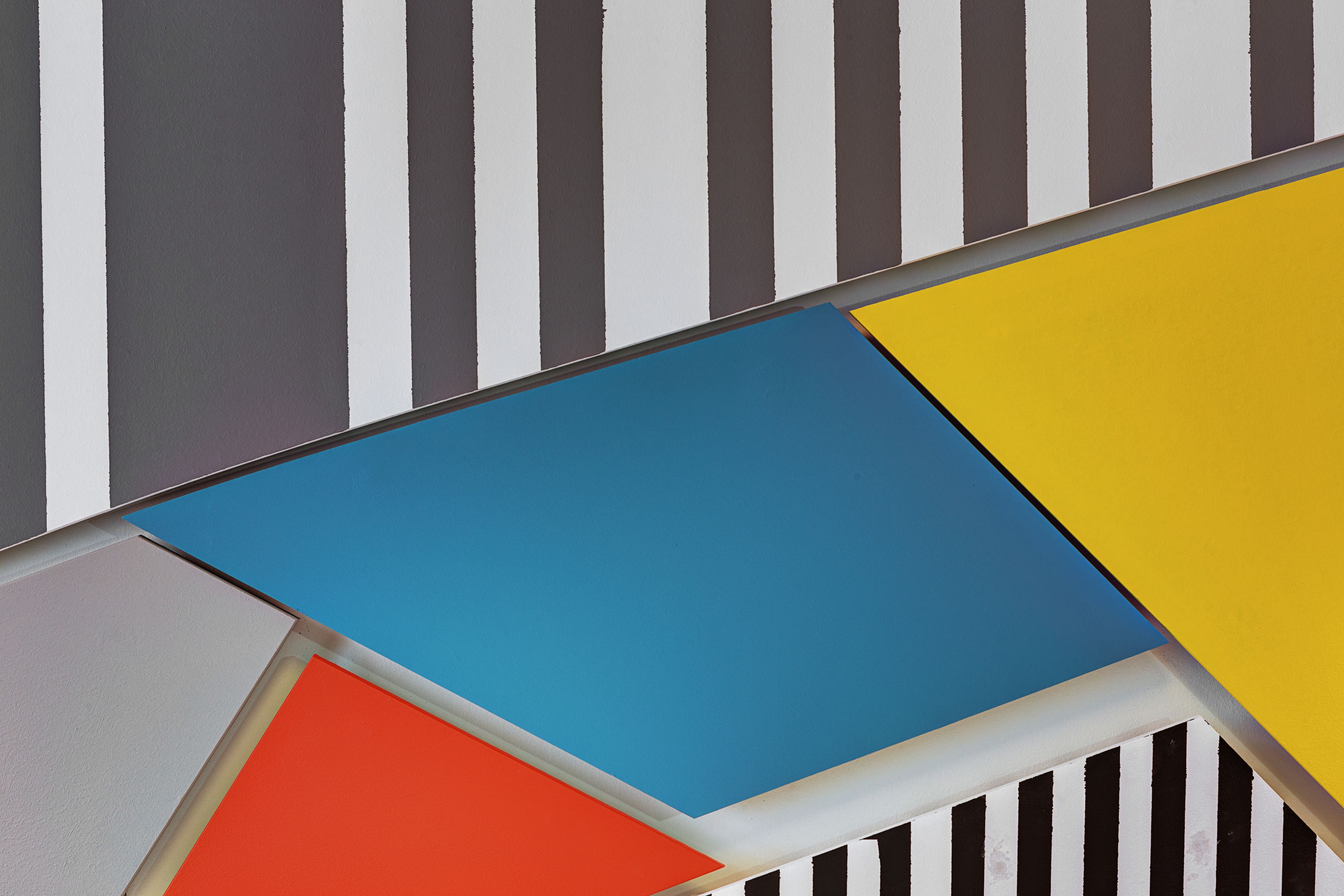 A geometric pattern with stripes and colored shapes.