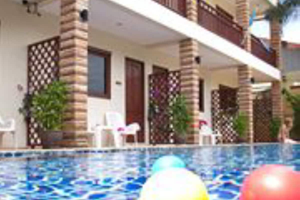 A swimming pool with a tiled pattern and three colorful balls.