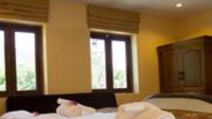 Una habitación de hotel con una cama, una mesita de noche y un armario.