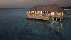 An overwater bungalow with a thatched roof, multiple bedrooms, and a pool. - COMO Maalifushi (Maalefushi)