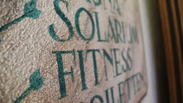 Una pared con el texto "SOLARIUM FITNESS" y "TOILETTE" escrito.