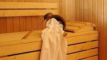 Un sauna avec des bancs en bois et un banc muni d’une serviette.