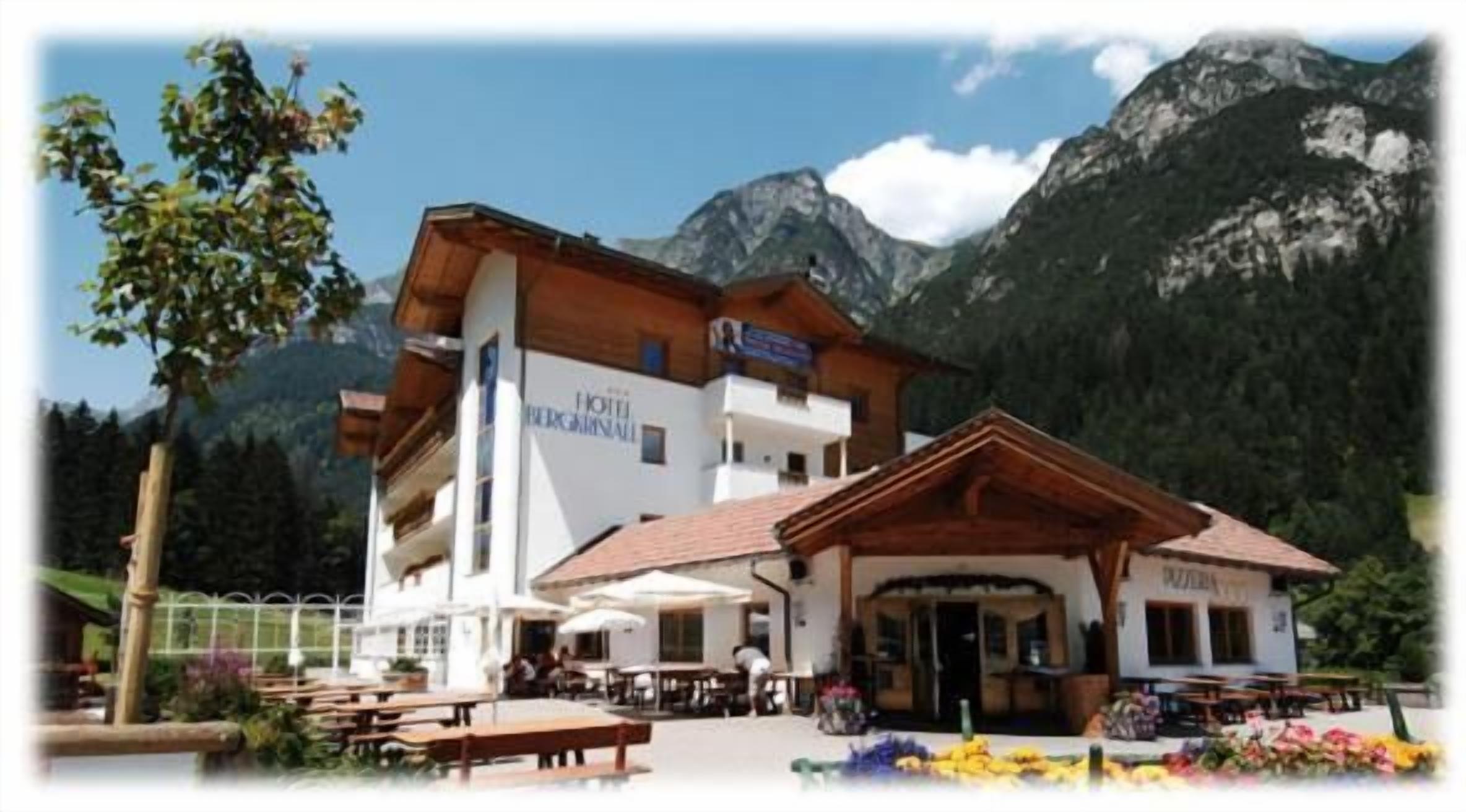 Un chalet de montagne doté d’un espace repas et de sièges extérieurs, situé au cœur d’un paysage montagneux.