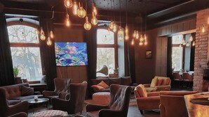 A cozy lounge area with leather sofas, a coffee table, and hanging light fixtures. - Statt Kristinehamn (Kristinehamn)