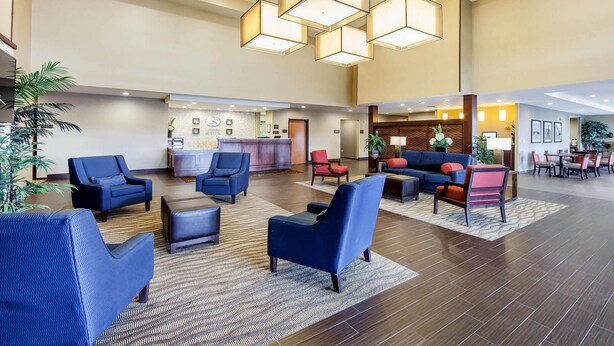 A spacious lobby with multiple seating areas, a reception desk, and a dining area.