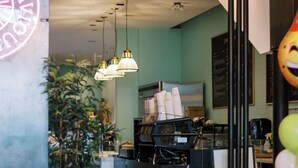 L’intérieur d’un café, avec un comptoir, des lampes suspendues et un néon.