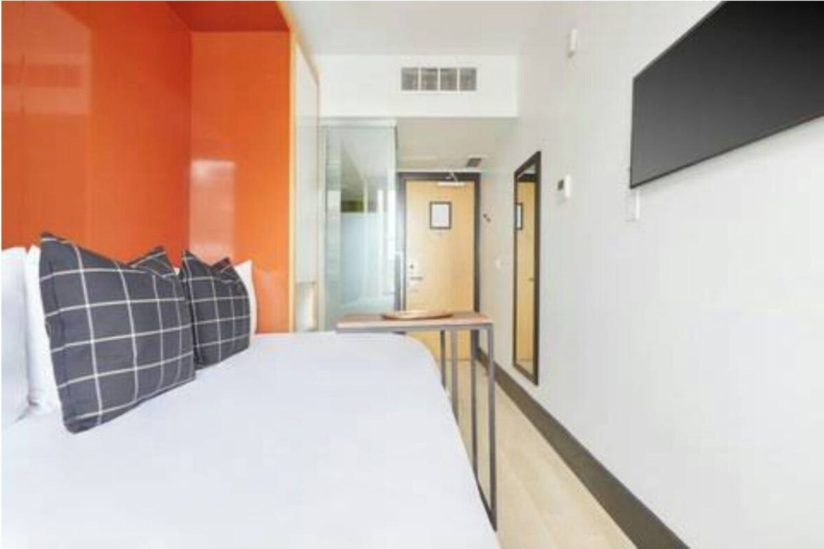 Habitación de hotel con cama, una mesita y un espejo.