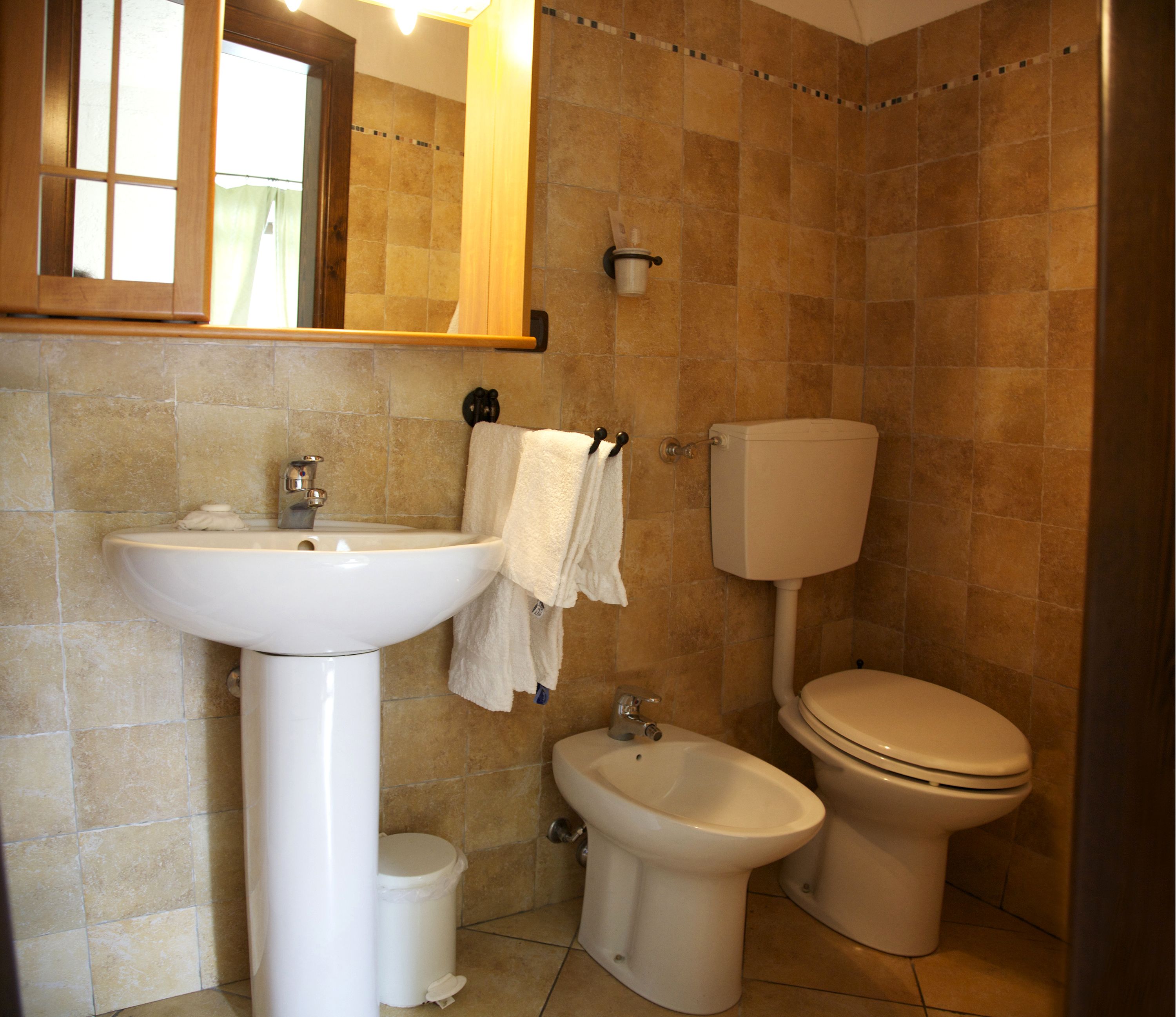 Ein Badezimmer mit Waschbecken, Bidet, Toilette und Spiegel.
