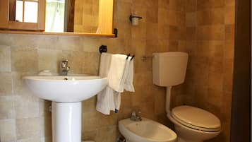 Ein Badezimmer mit Waschbecken, Bidet, Toilette und Spiegel.
