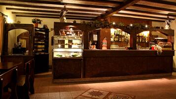 A bar area with a display case, wooden furniture, and a tiled floor.