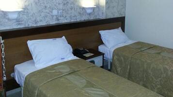 A hotel room with two beds, a marble wall, a painting, and an air conditioning unit.