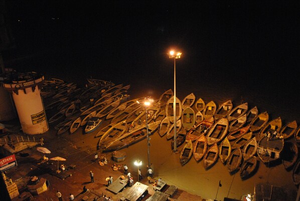 Vista nocturna de un muelle con numerosas embarcaciones alineadas.