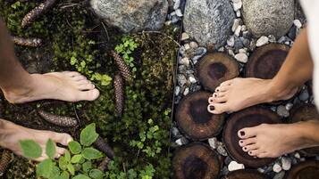 Feet resting on mossy ground and wooden logs.