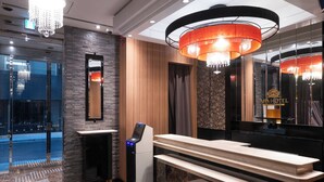 A modern bathroom with a marble countertop, a digital kiosk, and a large mirror. - APA Hotel Ginza Kyobashi Minami (Tokyo)