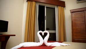 A hotel room with a bed, a TV on a stand, and a window with curtains. - Hotel Catedral Casa Cornejo (Alajuela)