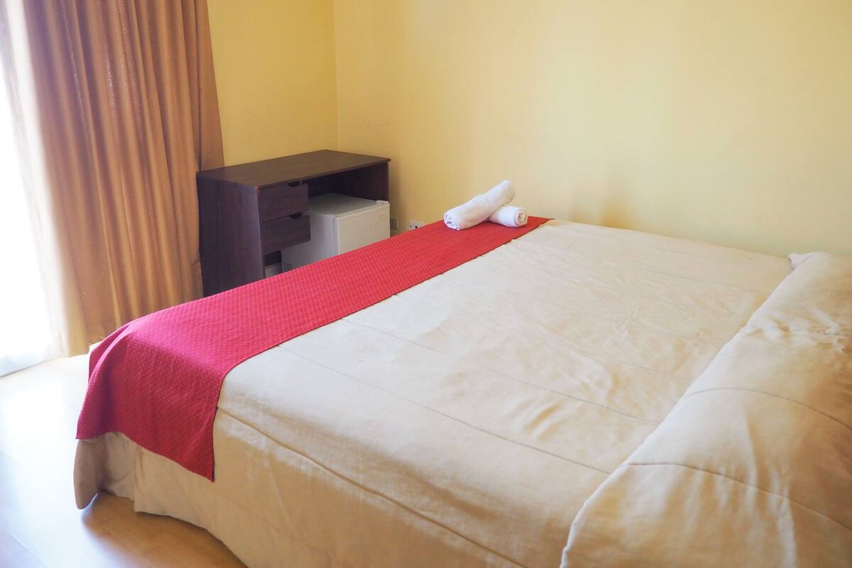 Een hotelkamer met een bed, een bureau en een stoel.