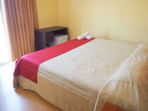 Une chambre d’hôtel avec un lit, un bureau et une chaise.