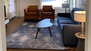 A modern living room with a sofa, two armchairs, a coffee table, and a floor lamp. - The Ocean Front at Seaside (Seaside)