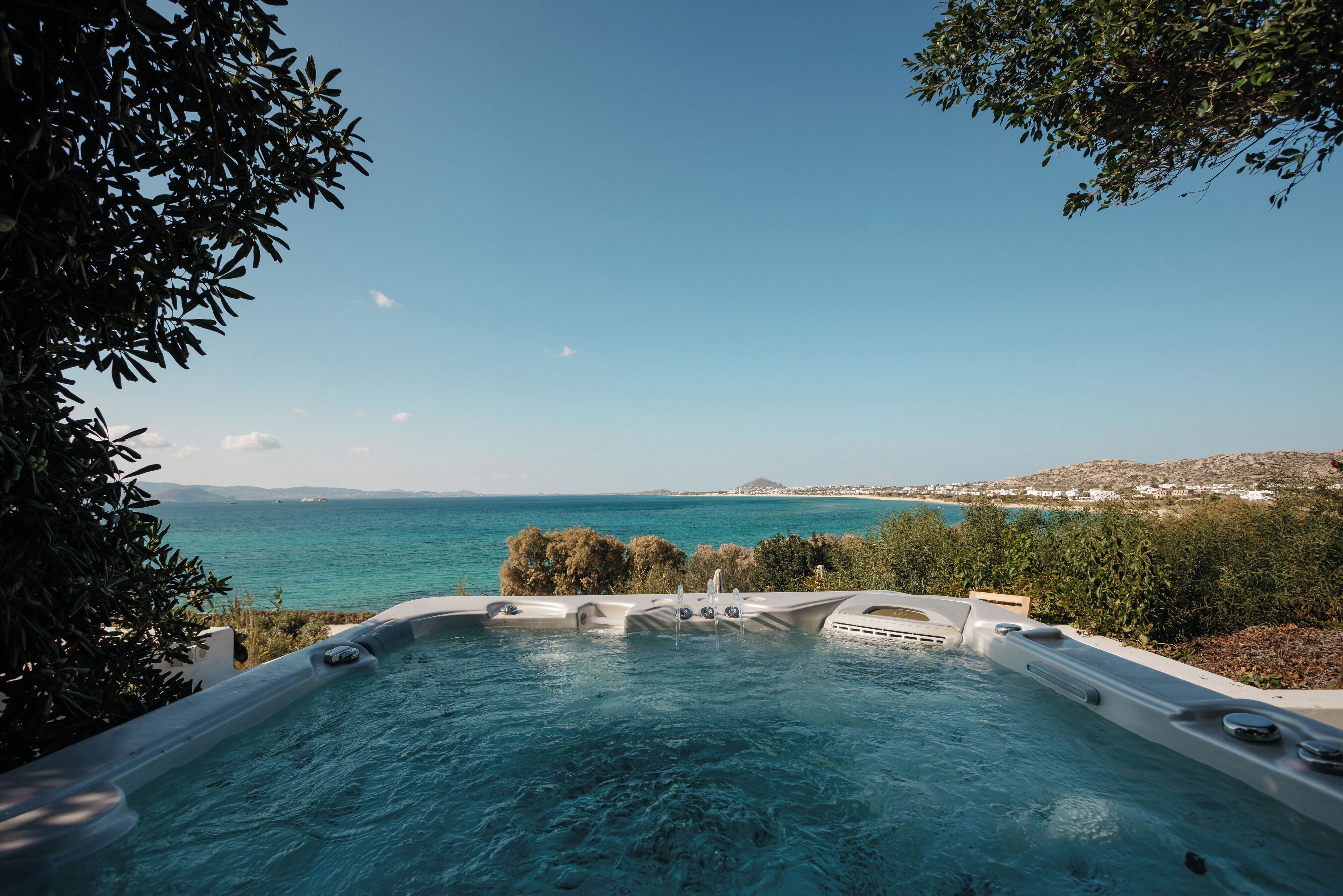 Un jacuzzi con vista despejada al mar y colinas lejanas.