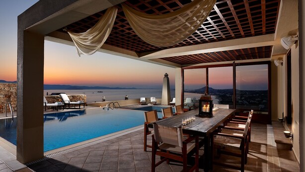 A rooftop pool area with a sunset view, a dining table with chairs, and a pergola with draped fabric. - Villa Paradise (Naxos)