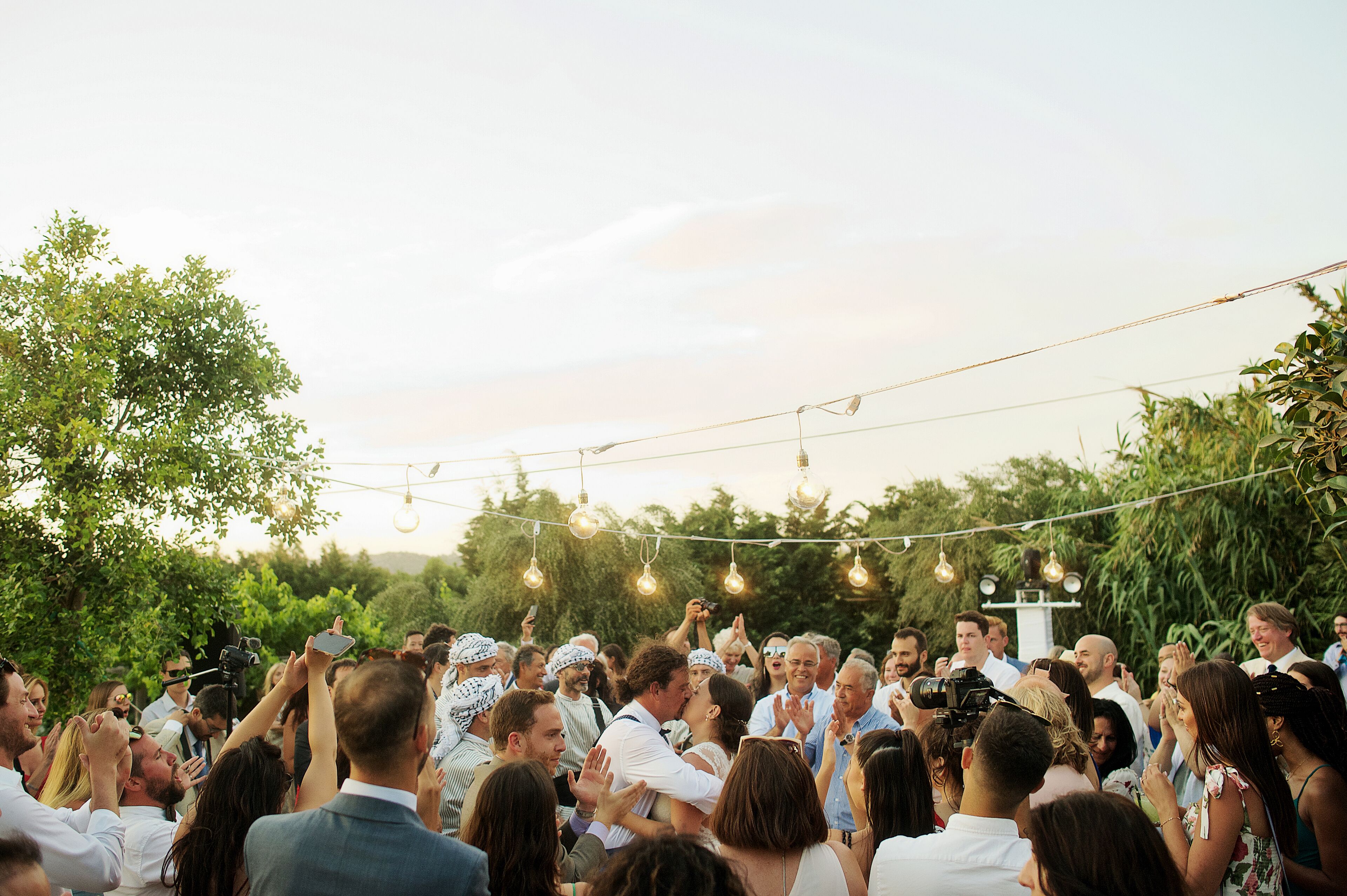 A wedding ceremony with guests and a photographer.
